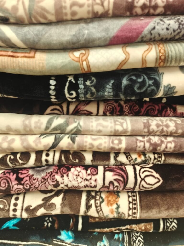 Stack of printed mink blankets in assorted designs