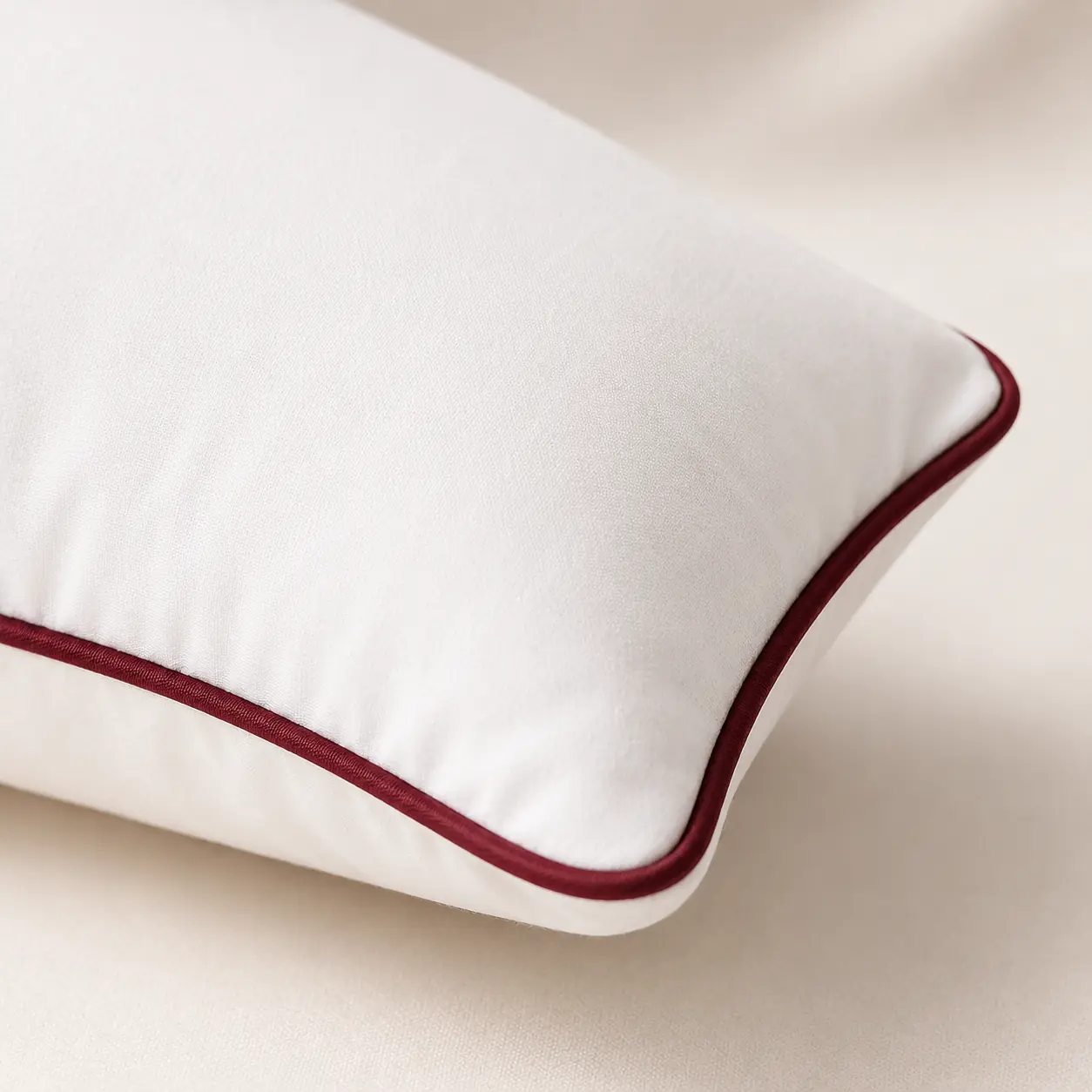 Close-up of wine-red piping and white pillow fabric