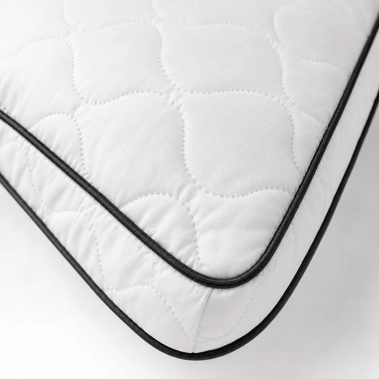 Close-up of white quilted fabric and black piping